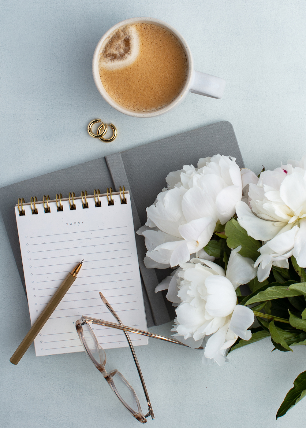 Flowers and notebook on closed laptop